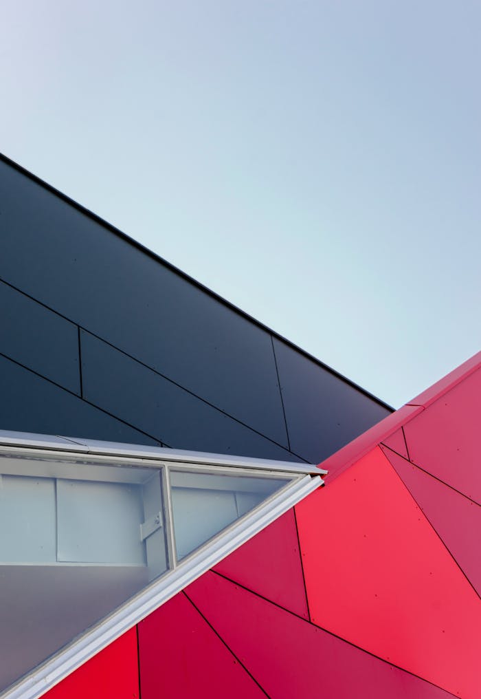 services-03 A low-angle view of a modern geometric building facade with bold colors in London, ON, Canada.