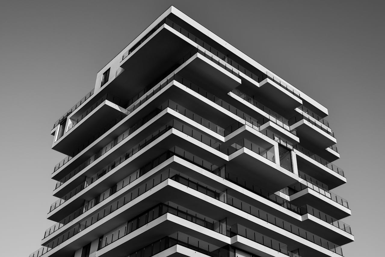 services-01 A striking black and white photo of a modern high-rise building with unique geometric designs.